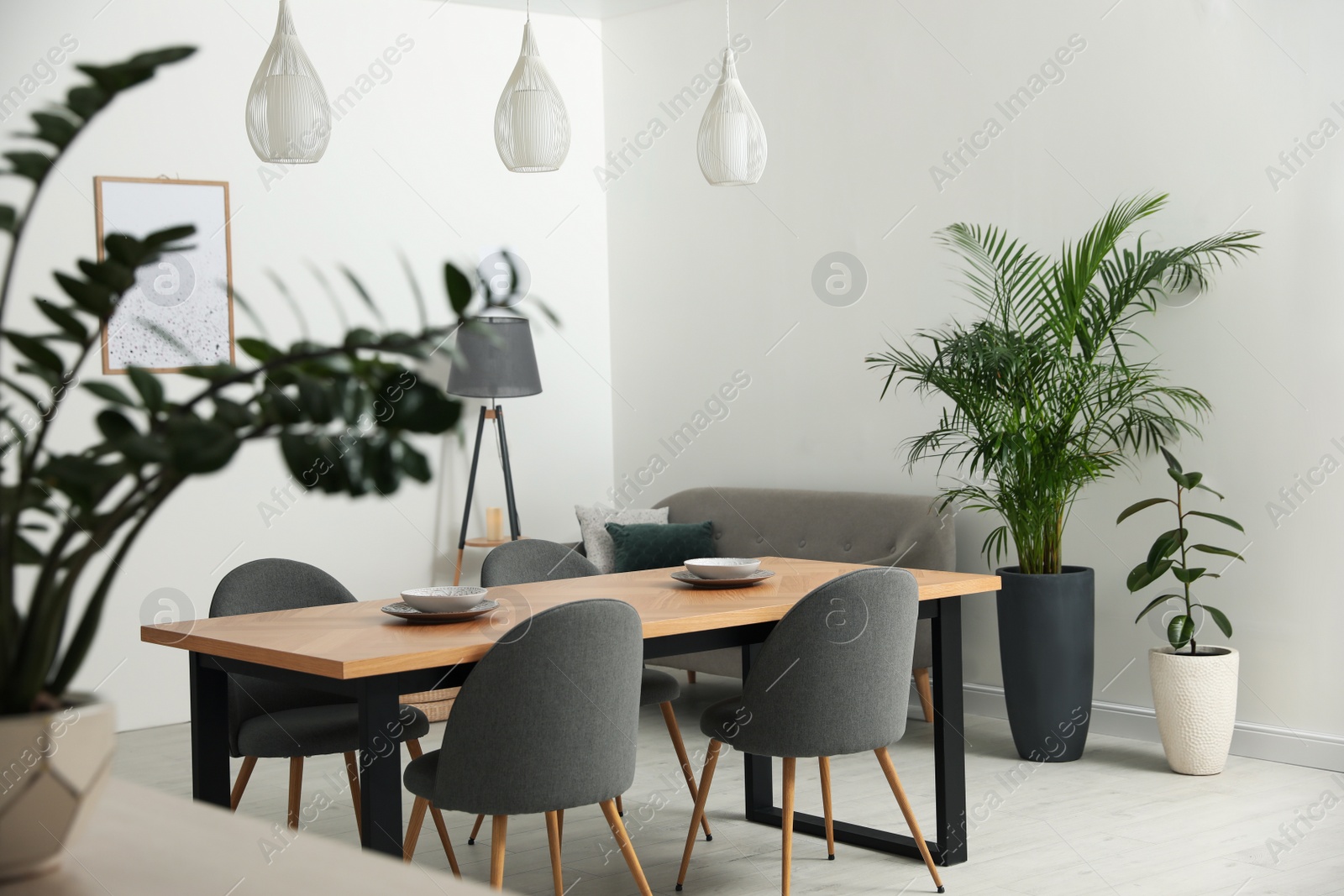 Photo of Stylish wooden table and chairs in light room. Modern interior design