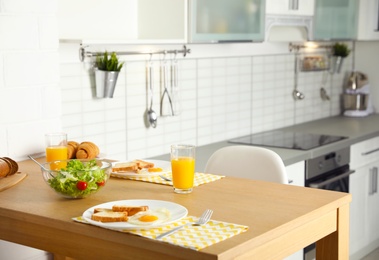 Photo of Tasty breakfast served on table in kitchen
