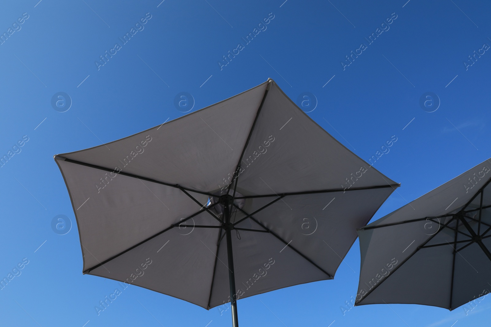 Photo of Beach umbrellas against blue sky on sunny day