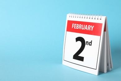 Calendar with date February 2nd on light blue background, space for text. Groundhog day