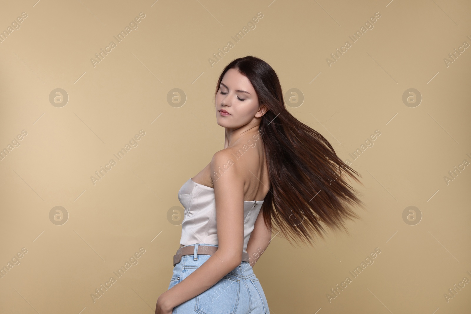 Photo of Portrait of beautiful young woman with healthy strong hair on beige background