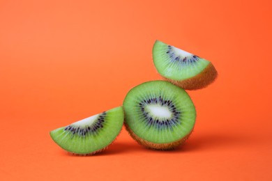 Photo of Cut fresh ripe kiwis on orange background