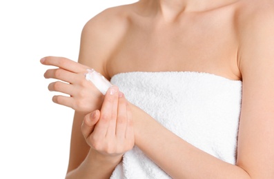 Young woman applying hand cream on white background