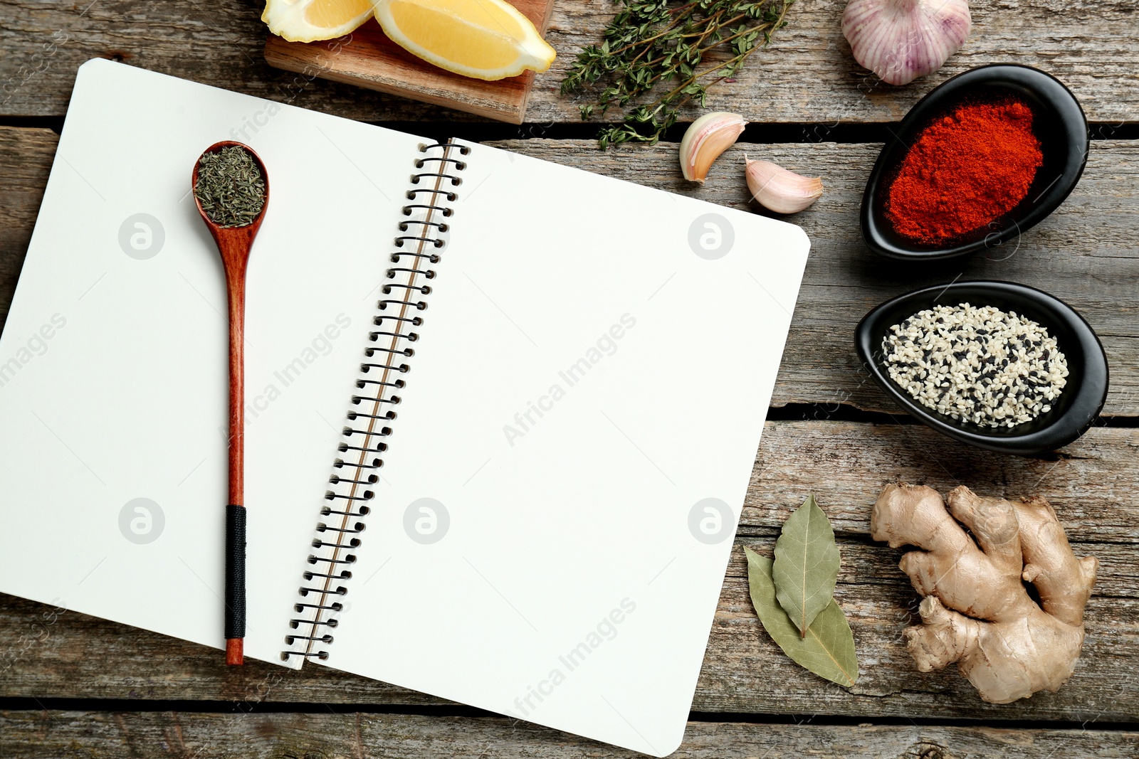 Photo of Blank recipe book and different ingredients on old wooden table, flat lay. Space for text