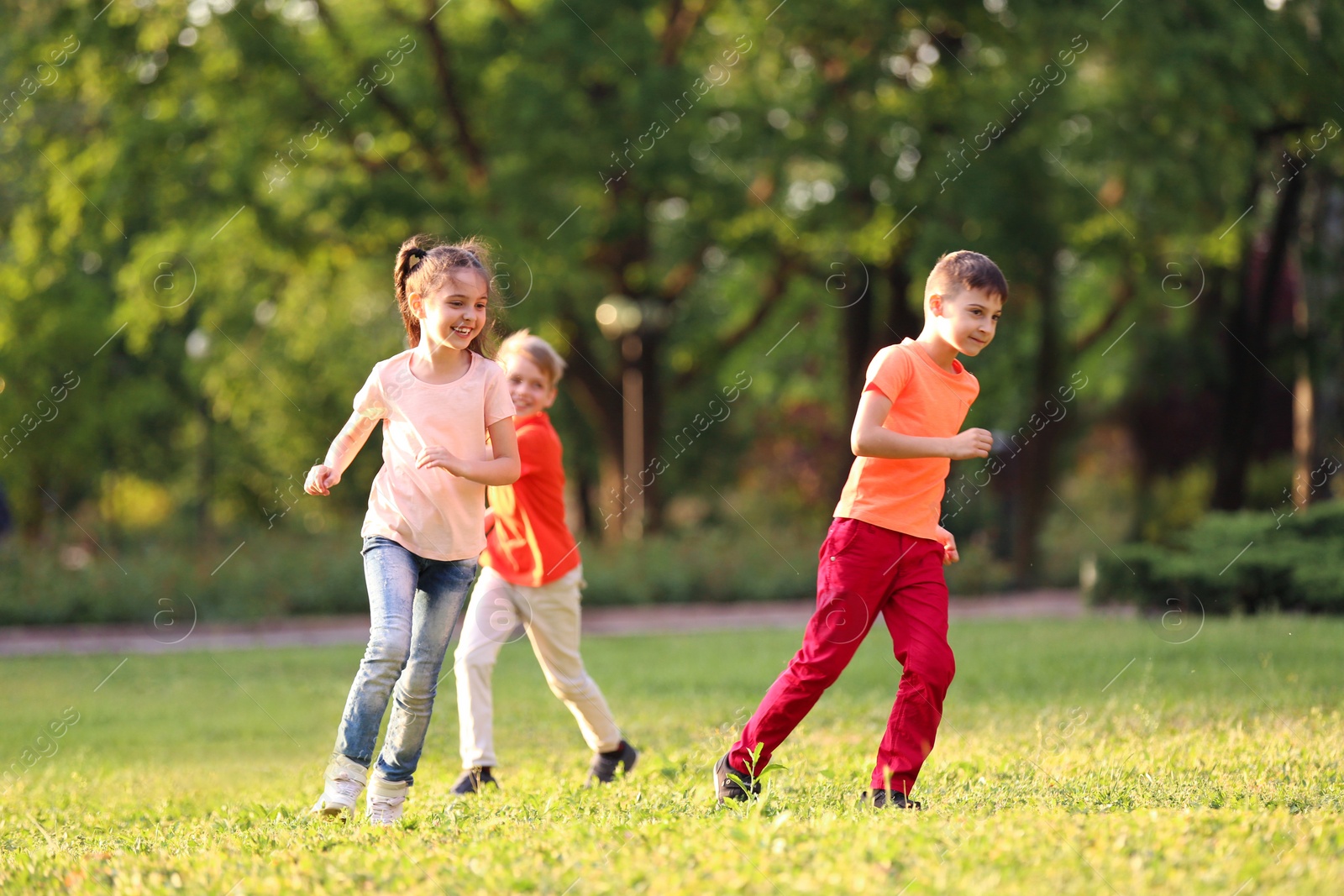 Photo of Cute little children playing together outdoors on sunny day