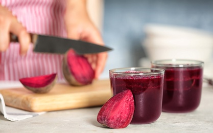 Glasses of beet smoothies and blurred woman on background