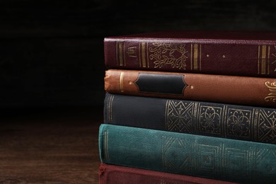 Photo of Stack of old hardcover books on wooden table, closeup. Space for text