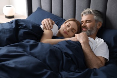 Photo of Lovely mature couple sleeping together in bed at home