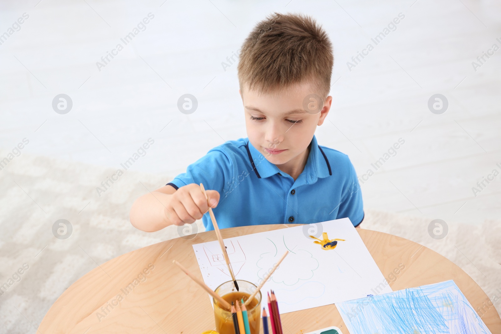 Photo of Cute little children painting at table in playing room