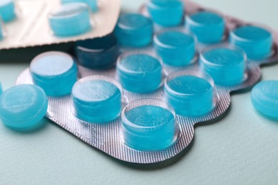 Photo of Blue cough drops on grey background, closeup