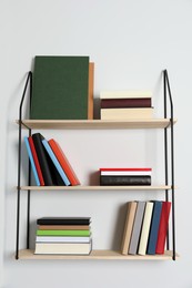 Shelves with many hardcover books on white wall