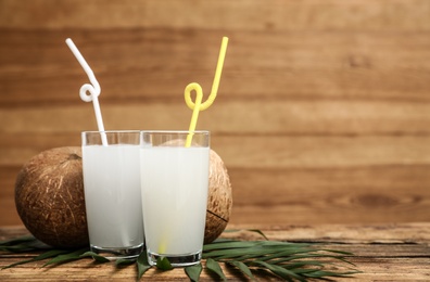 Composition with glasses of coconut water on wooden background. Space for text