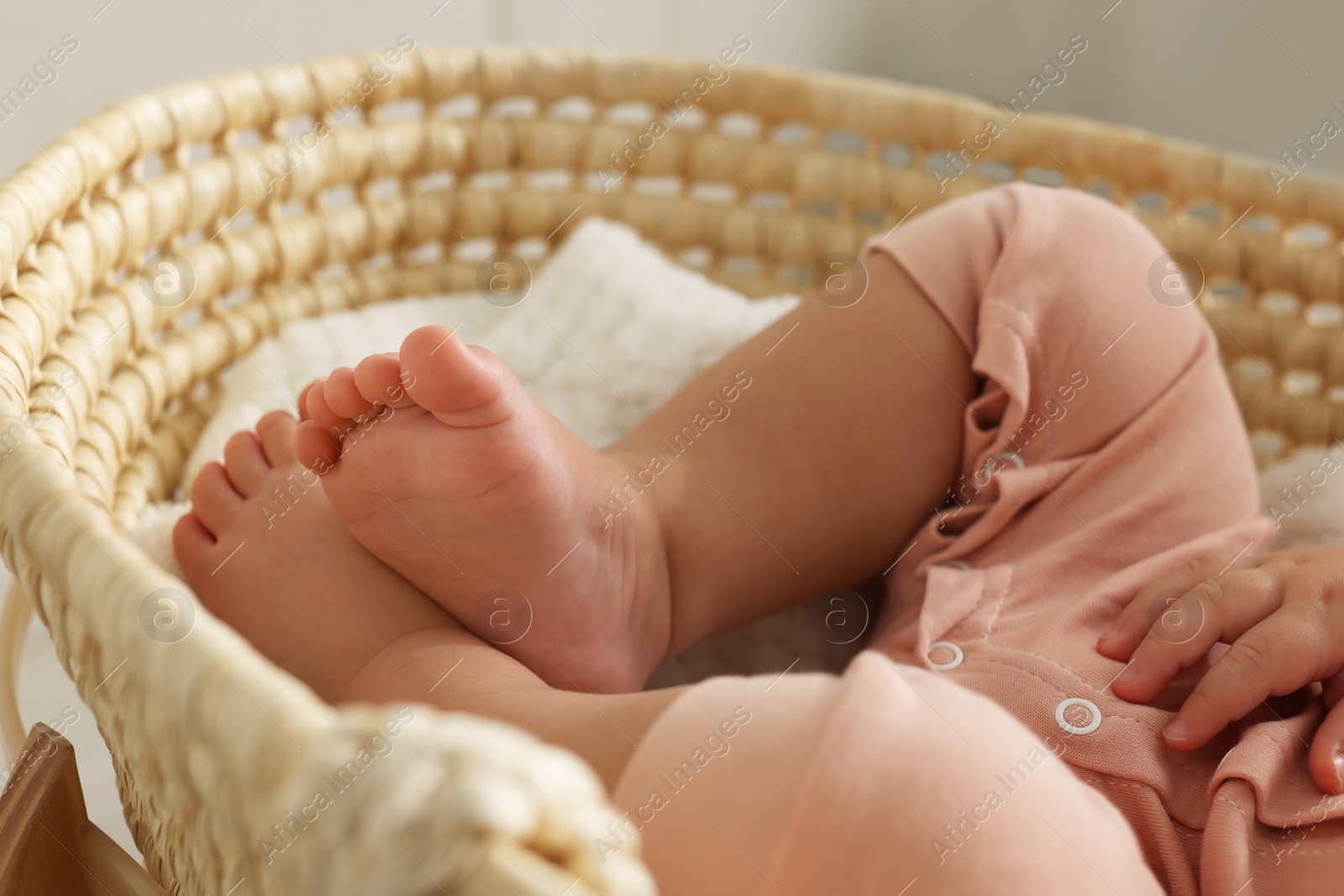 Photo of Cute little baby sleeping in wicker crib at home, closeup