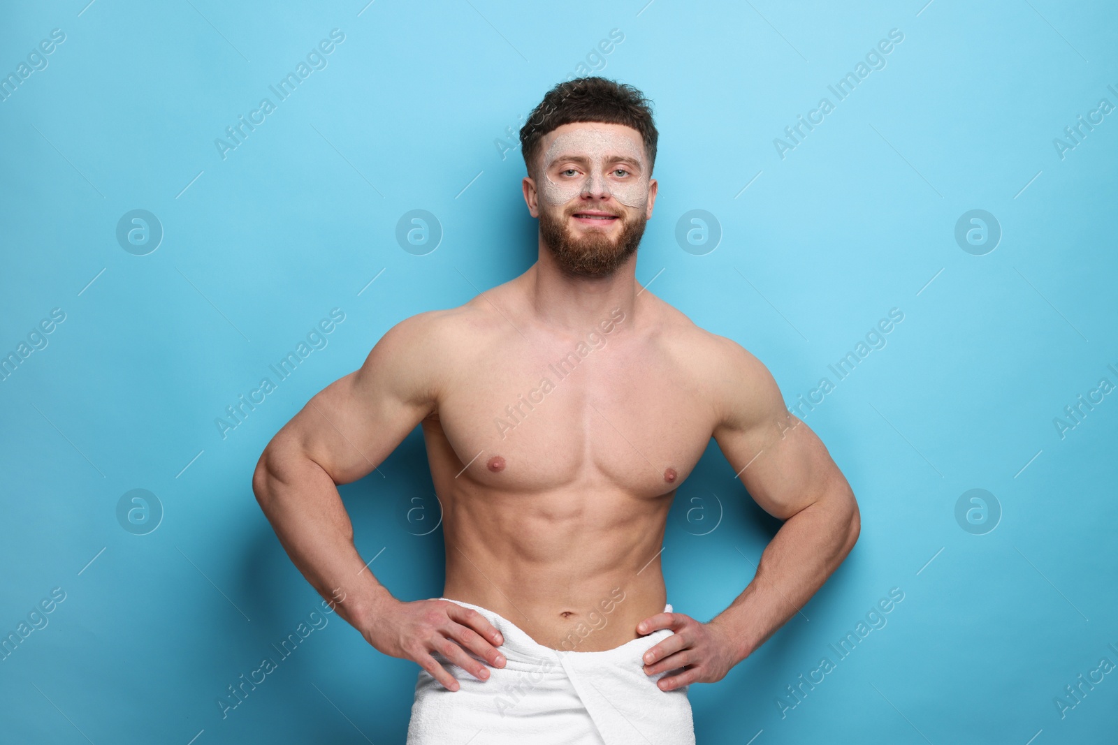 Photo of Handsome man with facial mask on his face against light blue background