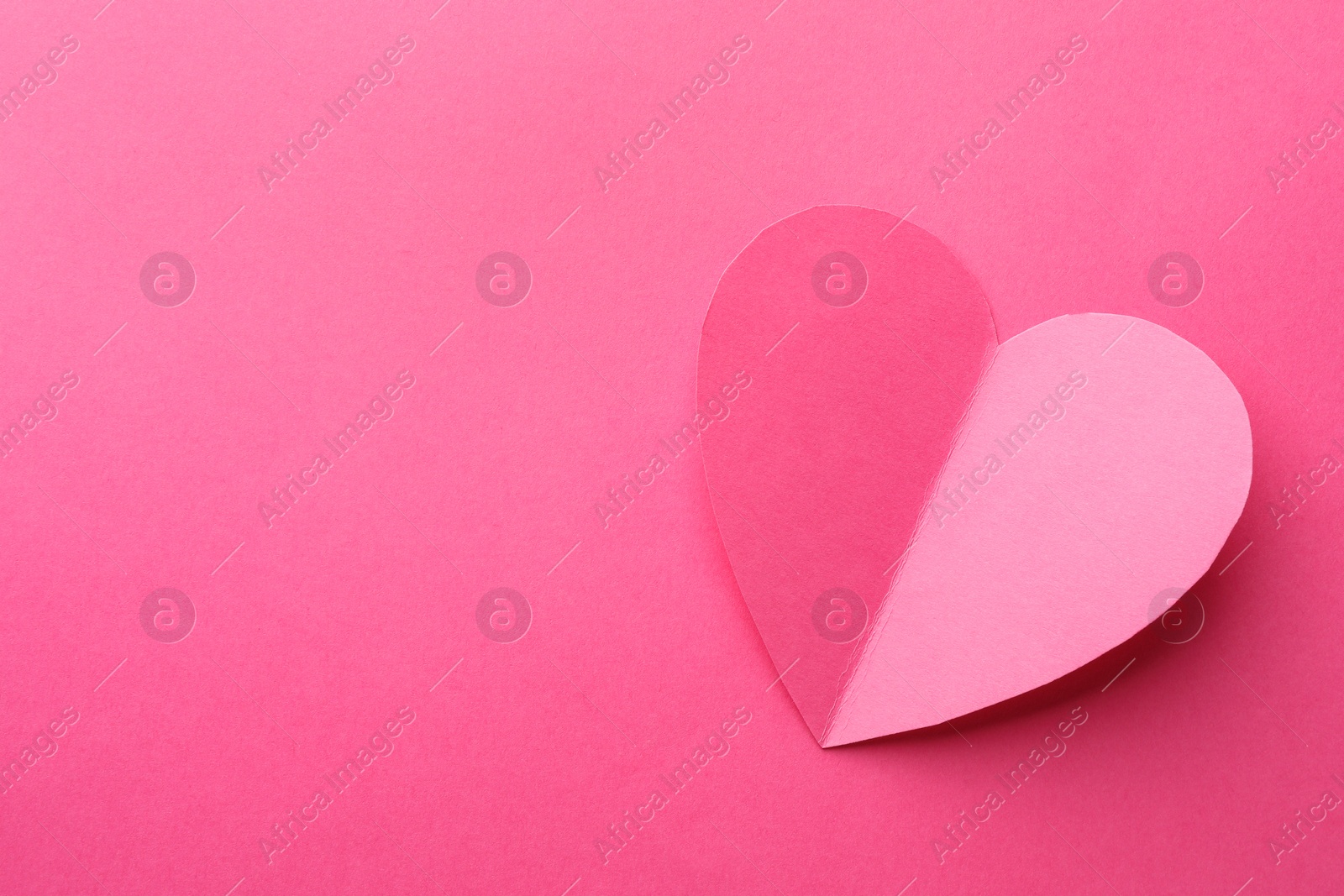 Photo of Paper heart on pink background, top view. Space for text