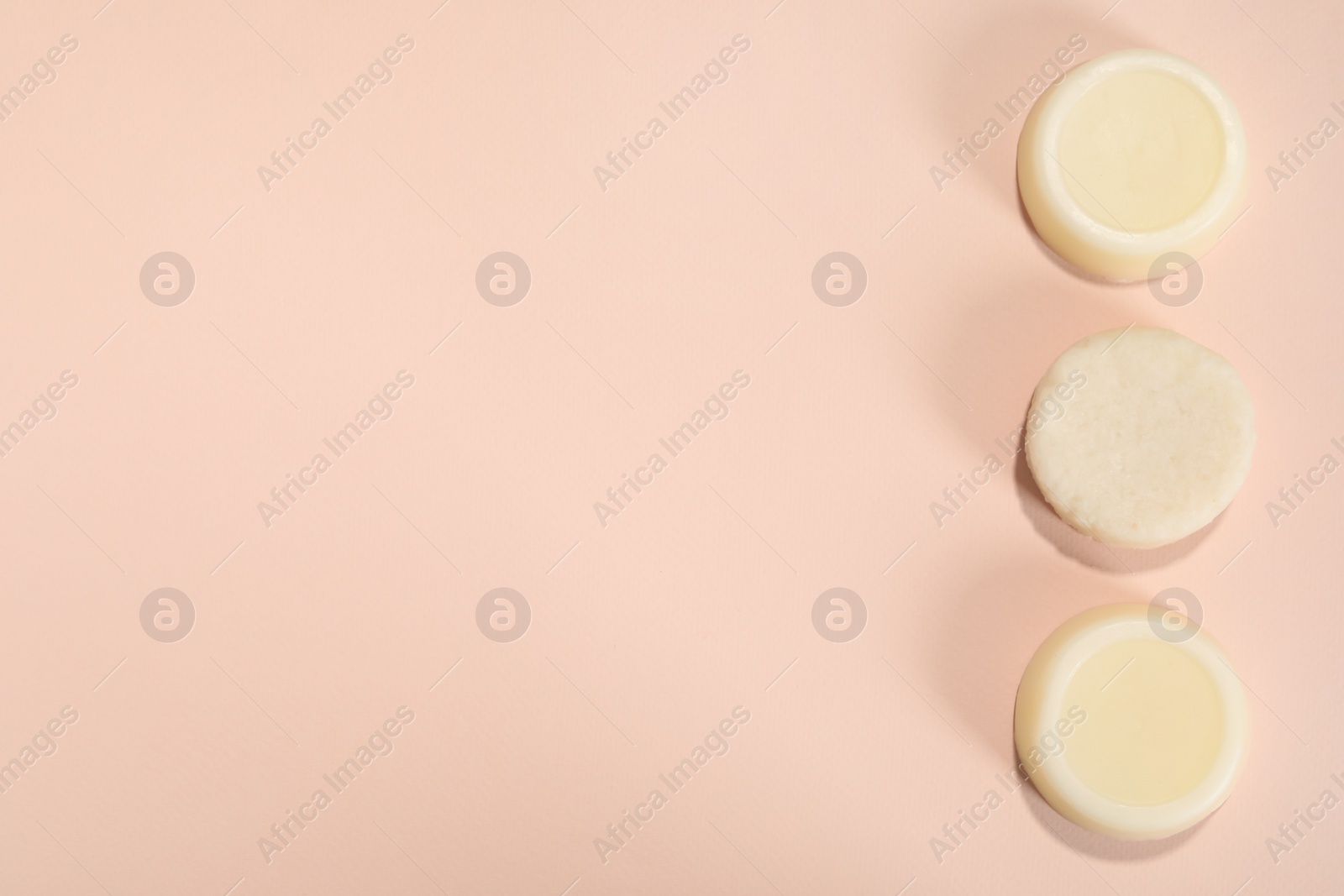 Photo of Set of solid shampoo bars on pink background, flat lay. Space for text