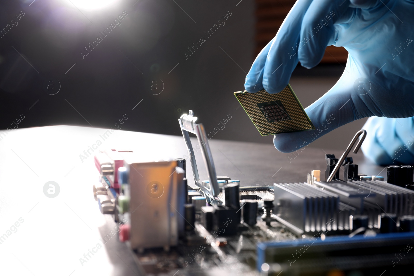 Photo of Technician repairing computer motherboard at table, closeup. Electronic device