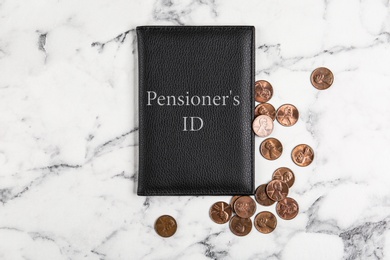 Pension certificate with American coins on marble table, flat lay