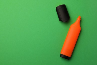 Bright orange marker on green background, flat lay. Space for text