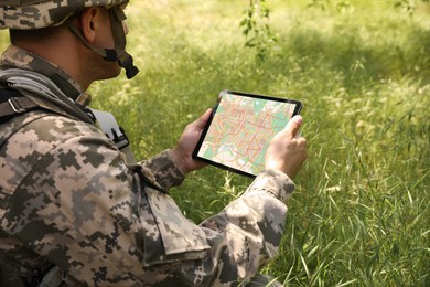 Photo of Soldier using tablet in forest. Modern technology