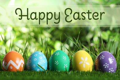 Image of Colorful eggs in green grass and text Happy Easter on blurred background