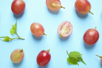 Flat lay composition with fresh ripe juicy grapes on light blue background