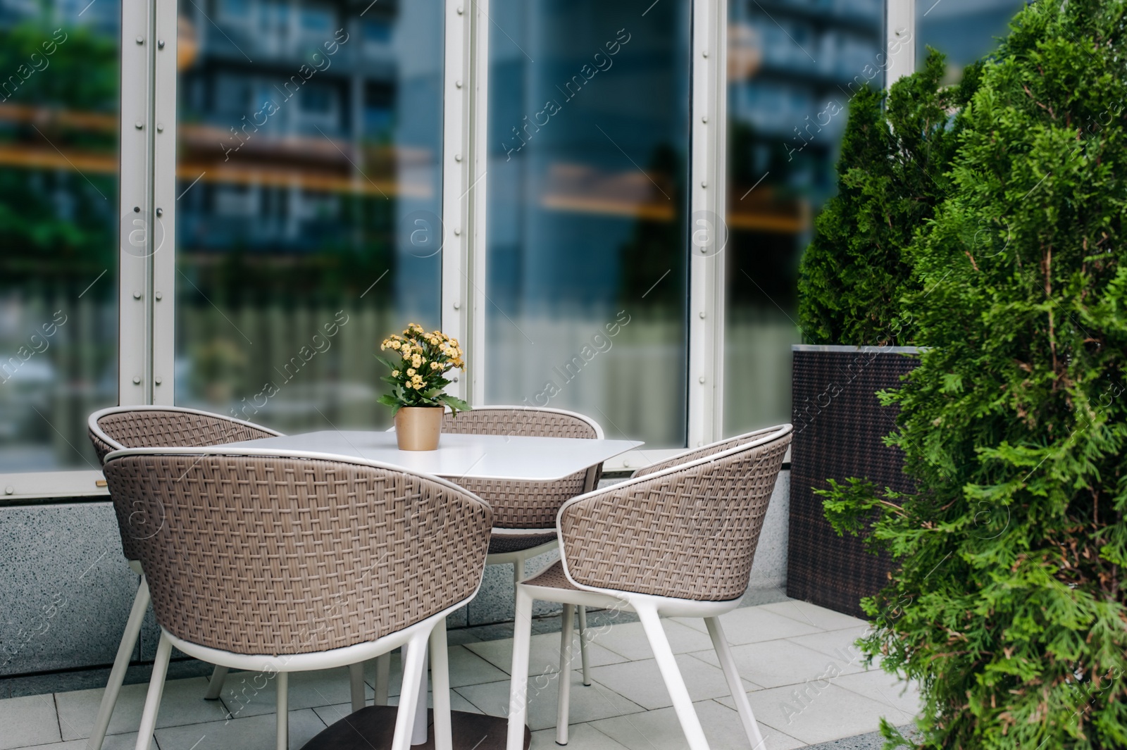 Photo of Table and comfortable chairs near cafe outdoors