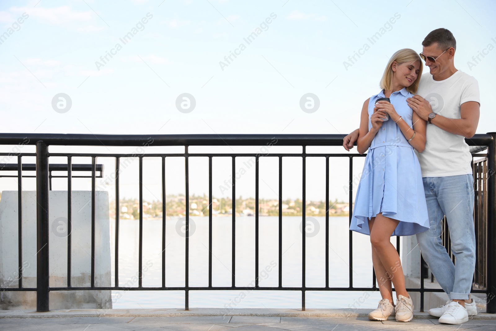 Photo of Happy couple with drink on city waterfront