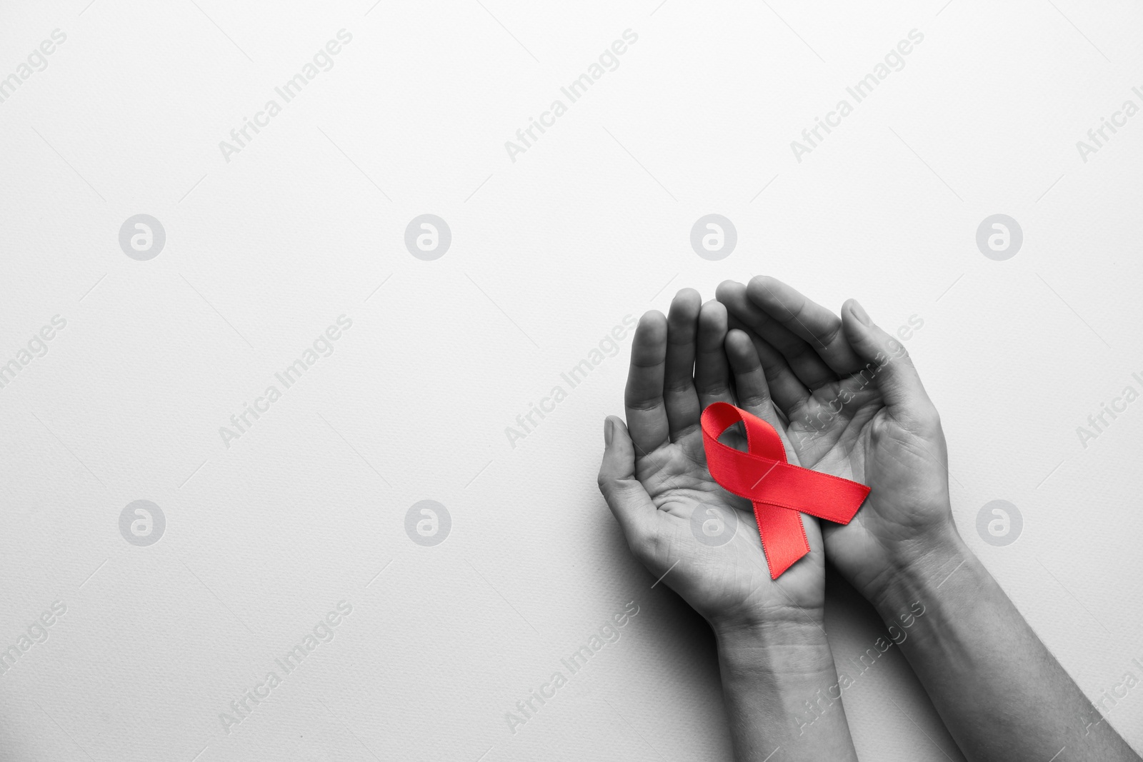 Image of World AIDS disease day. Woman holding red awareness ribbon on white background, top view with space for text