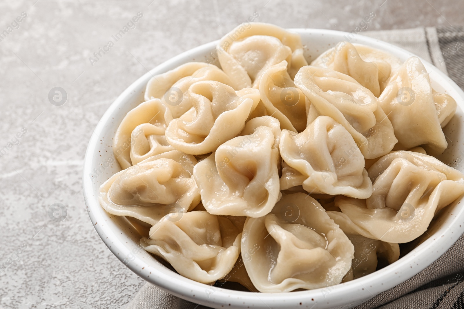 Photo of Tasty dumplings in bowl on marble table