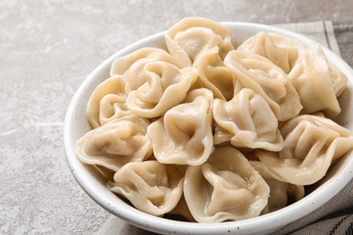 Photo of Tasty dumplings in bowl on marble table