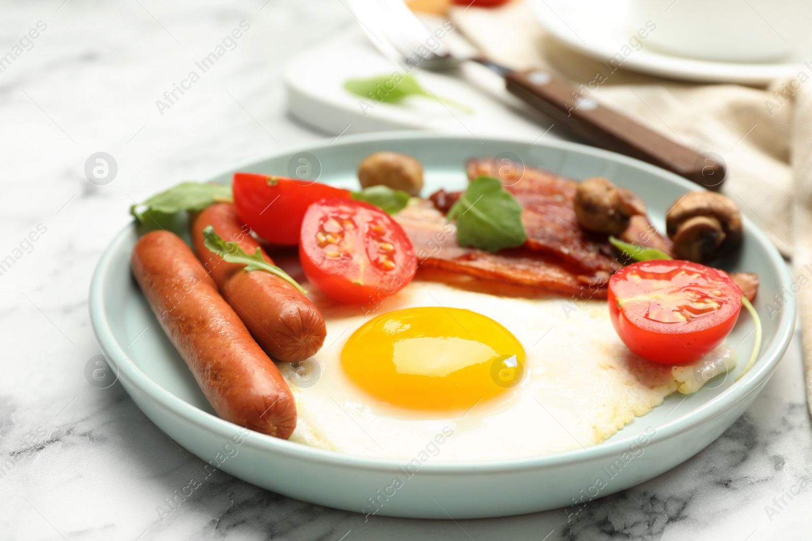 Photo of Tasty breakfast with fried egg on white marble table, closeup