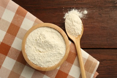 Photo of Baking powder in bowl and spoon on wooden table, top view