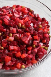 Photo of Bowl of delicious fresh vinaigrette salad on table, closeup