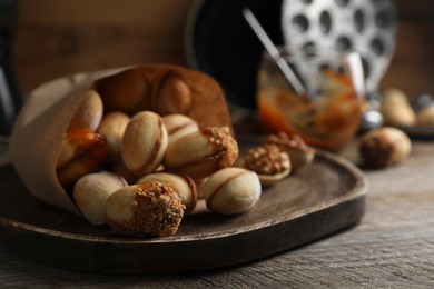 Photo of Freshly baked homemade walnut shaped cookies on wooden table, closeup. Space for text