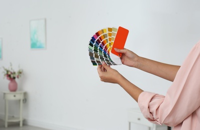 Photo of Female interior designer with color palette samples indoors. Space for text