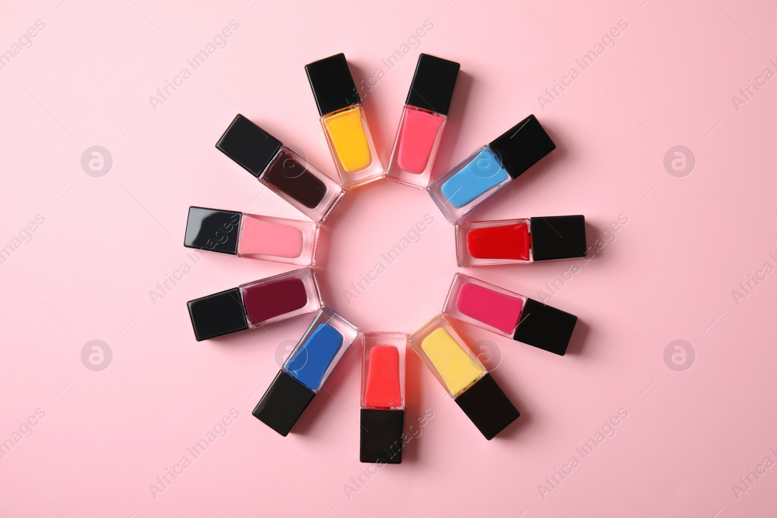 Photo of Flat lay composition with bottles of nail polish and space for text on color background