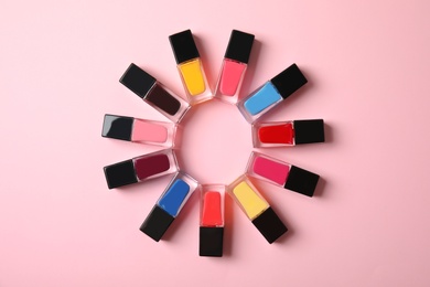 Photo of Flat lay composition with bottles of nail polish and space for text on color background