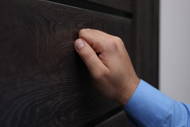 Collection agent knocking on wooden door, closeup