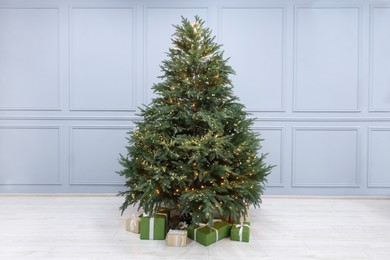 Photo of Many different gift boxes under Christmas tree indoors