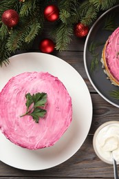 Herring under fur coat salad and Christmas decor on wooden table, flat lay. Traditional Russian dish