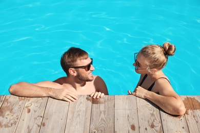 Photo of Happy young couple in swimming pool at resort