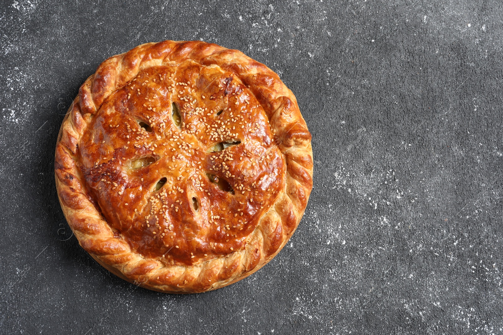 Photo of Tasty homemade pie on grey table, top view. Space for text