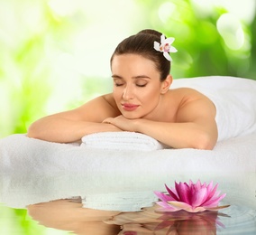 Beautiful young woman relaxing on soft towel. Spa treatment