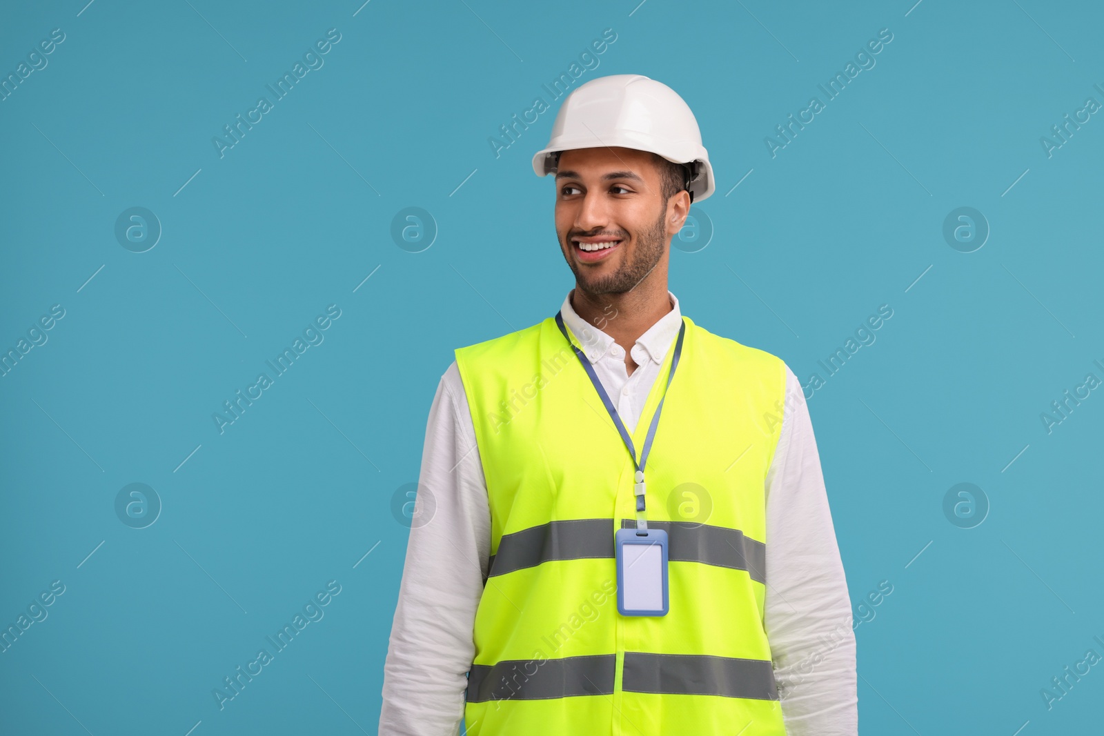 Photo of Engineer with hard hat and badge on light blue background, space for text