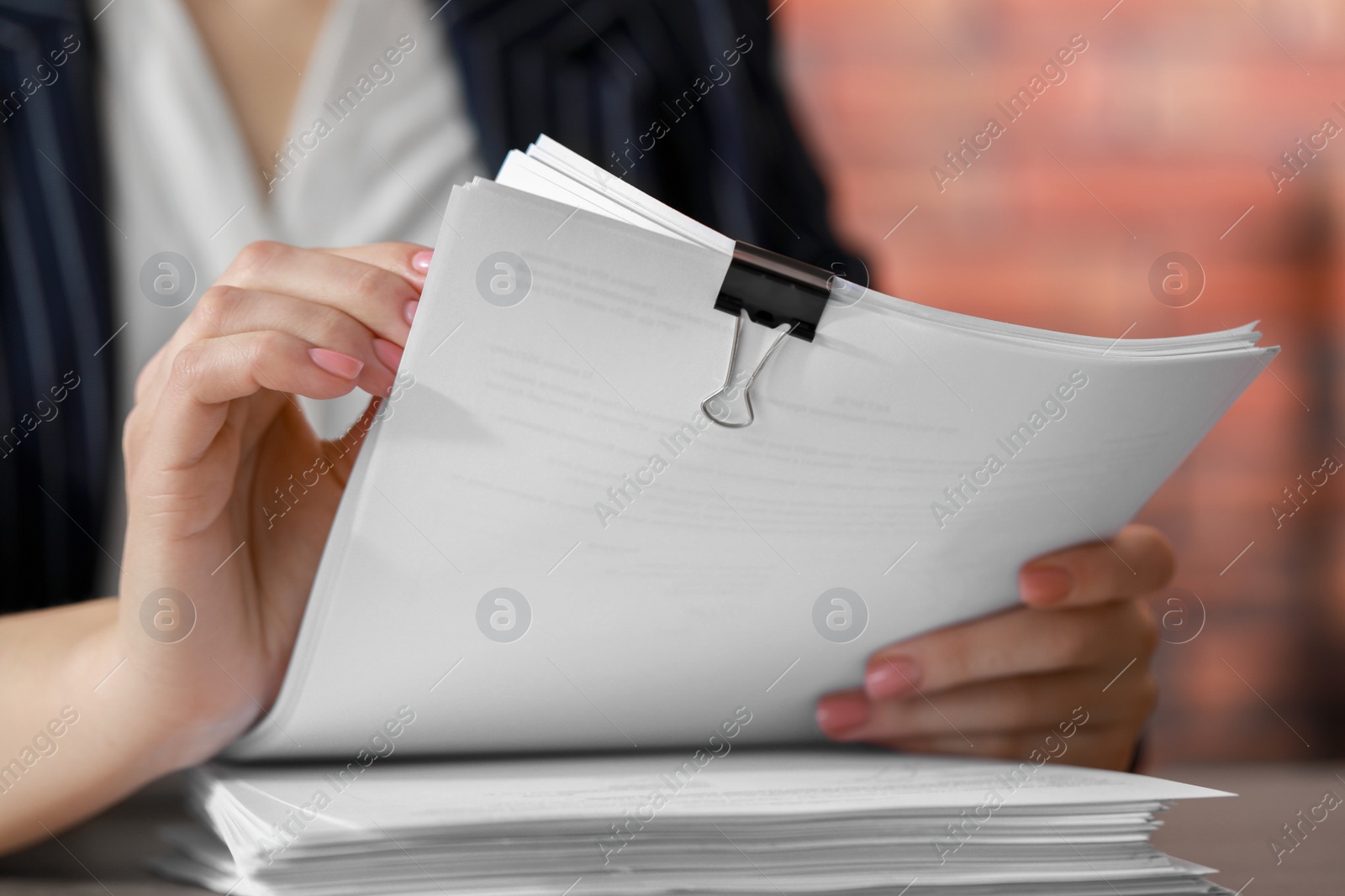 Photo of Woman stacking documents at table in office, closeup