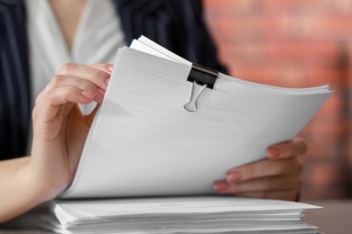 Photo of Woman stacking documents at table in office, closeup