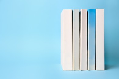 Photo of Collection of books on light blue background, space for text