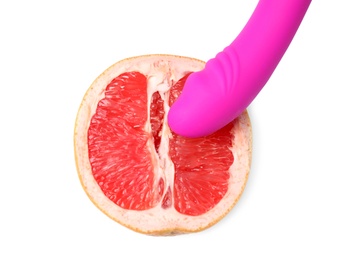 Half of grapefruit and purple vibrator on white background, top view. Sex concept