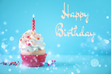 Delicious cupcake with candle on light blue background. Happy Birthday